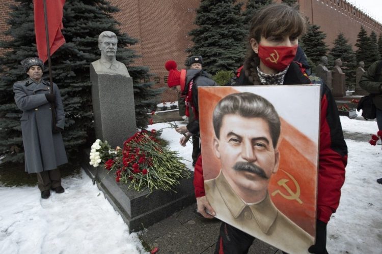Žena drží portrét sovietskeho vodcu Josifa Stalina po položení kvetov k jeho hrobu pri príležitosti 141. výročia jeho narodenia na Červenom námestí v Moskve, Rusko, pondelok 21. decembra 2020 (Foto: SITA/AP/Alexander Zemlianichenko)