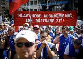 Účastníci s transparentom počas verejného protestného zhromaždenia Odborového zväzu (OZ) KOVO za zastavenie rozvratu sociálneho štátu na Námestí SNP v Bratislave. Bratislava, 26. jún 2021 (Foto: SITA/Branislav Bibel)
