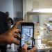 A journalist takes a cell phone photo of a scientist working on the development of Abdala, an experimental vaccine for COVID-19, at the Center for Genetic Engineering and Biotechnology (CIGB) in Havana, Cuba, Thursday, Feb. 25, 2021. (AP Photo/Ramon Espinosa)