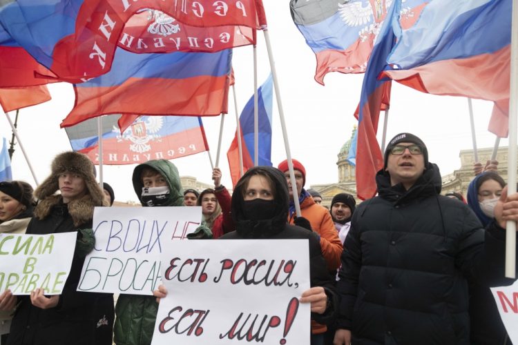 Prokremeľskí aktivisti a študenti sa zhromaždili s vlajkami Ruskej a Doneckej republiky a plagátmi s nápismi: "Neopúšťame svojich, Rusko je mier!" v Petrohrade v stredu 23. februára 2022 (Foto: SITA/AP Photo/Ivan Petrov)