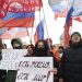Prokremeľskí aktivisti a študenti sa zhromaždili s vlajkami Ruskej a Doneckej republiky a plagátmi s nápismi: "Neopúšťame svojich, Rusko je mier!" v Petrohrade v stredu 23. februára 2022 (Foto: SITA/AP Photo/Ivan Petrov)