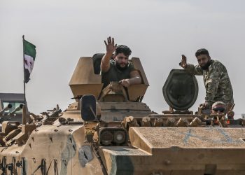 Tureckom podporovaní sýrski opoziční bojovníci mávajú počas jazdy na hranici do Sýrie v Akčakale, provincia Sanliurfa, juhovýchodné Turecko, 18. októbra 2019. Na severe Sýrie neuplynie takmer deň bez toho, aby si kurdskí bojovníci a opoziční ozbrojenci podporovaní Tureckom nevymieňali paľbu a ostreľovanie, a narastajú obavy, že situácia sa v najbližších týždňoch len zhorší, keďže Ankara hrozí spustením novej rozsiahlej operácie pozdĺž svojej južnej hranice (Foto: SITA/AP Photo/Emrah Gurel)