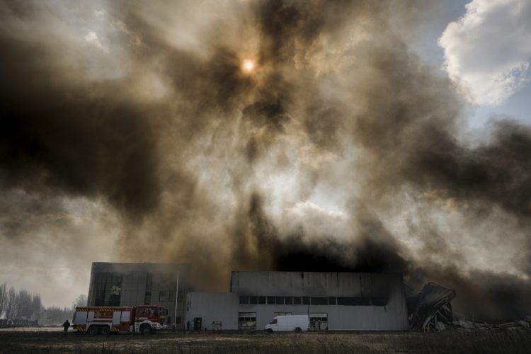 Hustý dym sa valí zo zničeného skladu po ruskom bombardovaní na predmestí Kyjeva na Ukrajine vo štvrtok 24. marca 2022 (Foto: SITA/AP Photo/Vadim Ghirda)