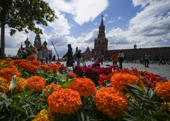 Ľudia prechádzajú okolo kvetov počas každoročného kvetinového festivalu pred obchodným domom GUM (vľavo) na Červenom námestí v Moskve v piatok 22. júla 2022 Foto: SITA/(AP Photo/Alexander Zemlianichenko)