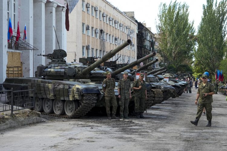 Vojaci Luhanskej ľudovej republiky stoja na výstave ukoristených ukrajinských tankov a zbraní v Lisičansku na území, ktoré je pod kontrolou vlády, na východe Ukrajiny v utorok 12. júla 2022. Táto fotografia vznikla počas cesty organizovanej ruským ministerstvom obrany (Foto: SITA/AP Photo)