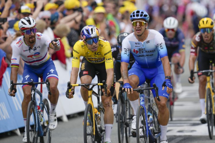 Víťaz etapy Holanďan Dylan Groenewegen (vpravo) prechádza cieľovou čiarou pred druhým Belgičanom Woutom Van Aertom, ktorý má na sebe žltý dres lídra celkového poradia, zatiaľ čo Slovák Peter Sagan (vľavo) ukazuje a sťažuje sa počas tretej etapy cyklistických pretekov Tour de France dlhej 182 km so štartom vo Vejle a cieľom v Sonderborgu v Dánsku v nedeľu 3. júla 2022. (Foto: SITA/AP Photo/Daniel Cole)
