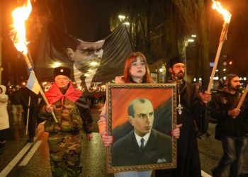 Aktivisti rôznych nacionalistických strán nesú pochodne a portrét Stepana Banderu počas zhromaždenia v Kyjeve, Ukrajina, sobota 1. januára 2022. Zhromaždenie bolo zorganizované pri príležitosti výročia narodenia Stepana Banderu (Foto: SITA/AP Photo/Efrem Lukatsky)
