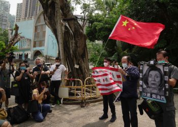 Priaznivci Číny držia americkú vlajku a fotografiu predsedníčky Snemovne reprezentantov USA Nancy Pelosiovej počas protestu pred generálnym konzulátom Spojených štátov v Hongkongu v stredu 3. augusta 2022. Predsedníčka Snemovne reprezentantov USA Nancy Pelosiová pricestovala v utorok neskoro večer na Taiwan a stala sa tak najvyššie postaveným americkým predstaviteľom za posledných 25 rokov, ktorý navštívil samosprávny ostrov nárokovaný Čínou, ktorá rýchlo oznámila, že v odvete za jej prítomnosť uskutoční vojenské manévre (Foto: SITA/AP Photo/Kin Cheung)