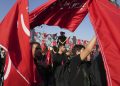 Smútiaci mávajú červenými vlajkami počas pohrebného obradu piatich príslušníkov iránskych polovojenských Revolučných gárd zabitých v Sýrii, ktorých pozostatky boli nedávno nájdené, v Teheráne, Irán, vo štvrtok 4. augusta 2022 (Foto: SITA/AP Photo/Vahid Salemi)