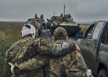 Ukrajinský vojak pomáha zranenému spolubojovníkovi na ceste na oslobodenom území v Charkovskej oblasti na Ukrajine v pondelok 12. septembra 2022. Ukrajinské jednotky v pondelok opätovne dobyli od Ruska rozsiahle územie, pričom sa na niektorých miestach posunuli až k severovýchodnej hranici, a tvrdia, že v rámci bleskového postupu, ktorý prinútil Moskvu k urýchlenému ústupu, zajali mnoho ruských vojakov (Foto: SITA/AP Photo/Kostiantyn Liberov)