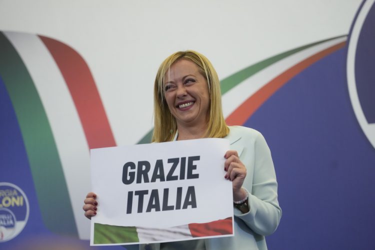 Líderka krajne pravicovej strany Bratia Talianska Giorgia Meloniová ukazuje plagát s nápisom v taliančine "Ďakujeme Taliansko" (Foto: SITA/AP Photo/Gregorio Borgia)