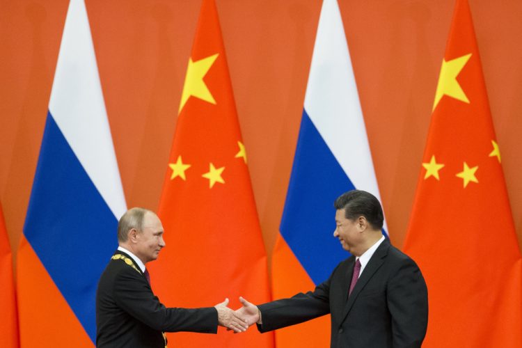 Čínsky prezident Si Ťin-pching (vpravo) a ruský prezident Vladimir Putin si podávajú ruky (Foto: SITA/AP Photo/Alexander Zemlianichenko)