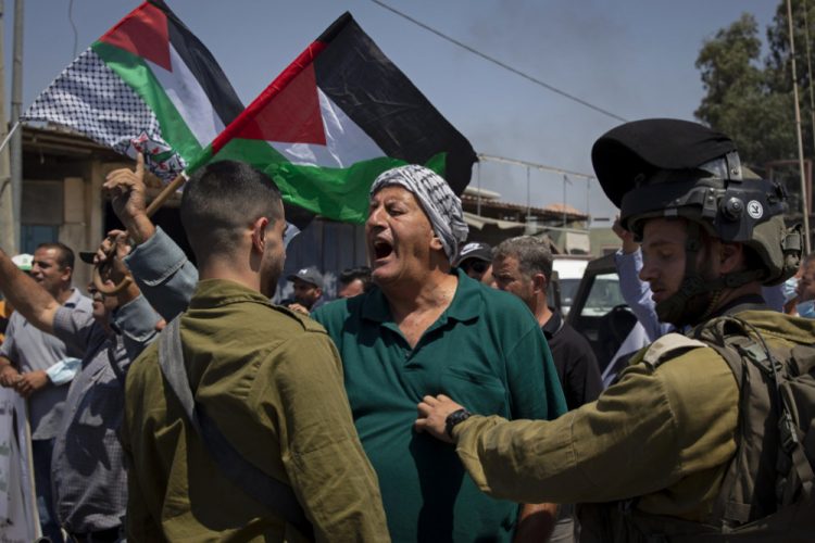 Palestínčan sa háda s izraelskými vojakmi počas protestu proti výstavbe novej cesty pre izraelských osadníkov pri palestínskej dedine Beita severne od mesta Nábulus na Západnom brehu Jordánu v stredu 25. augusta 2021 (Foto: SITA/AP Photo/Majdi Mohammed)