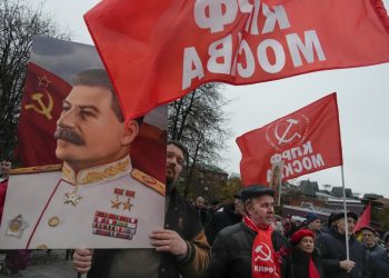 Stúpenec komunistickej strany nesie portrét Josifa Stalina počas demonštrácie pri príležitosti 105. výročia boľševickej revolúcie z roku 1917 neďaleko Červeného námestia v Moskve v pondelok 7. novembra 2022 (Foto: SITA/AP Photo/Alexander Zemlianichenko)