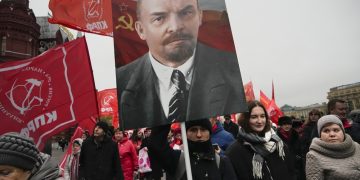 Priaznivci komunistickej strany nesú portréty zakladateľa Sovietskeho zväzu Vladimíra Lenina a kráčajú k Leninovmu hrobu počas demonštrácie pri príležitosti 105. výročia boľševickej revolúcie z roku 1917 na Červenom námestí v Moskve v pondelok 7. novembra 2022 (Foto: SITA/AP Photo/Alexander Zemlianichenko)