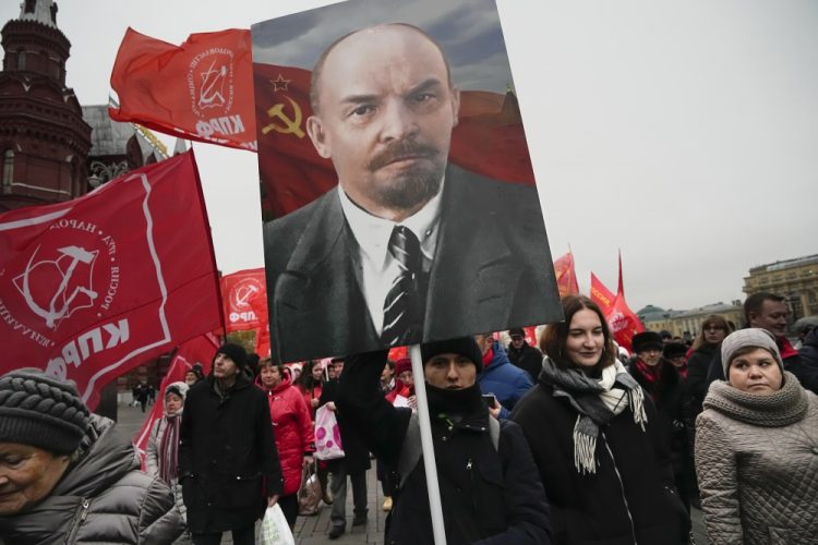 Priaznivci komunistickej strany nesú portréty zakladateľa Sovietskeho zväzu Vladimíra Lenina a kráčajú k Leninovmu hrobu počas demonštrácie pri príležitosti 105. výročia boľševickej revolúcie z roku 1917 na Červenom námestí v Moskve v pondelok 7. novembra 2022 (Foto: SITA/AP Photo/Alexander Zemlianichenko)