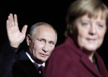 Na snímke ruský prezident Vladimir Putin máva po stretnutí s nemeckou kancelárkou Angelou Merkelovou na summite s lídrami Ruska, Ukrajiny a Francúzska v kancelárii v Berlíne 19. októbra 2016 (Foto: SITA/AP Photo/Markus Schreiber)
