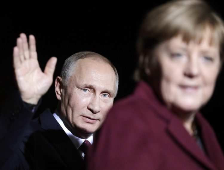 Na snímke ruský prezident Vladimir Putin máva po stretnutí s nemeckou kancelárkou Angelou Merkelovou na summite s lídrami Ruska, Ukrajiny a Francúzska v kancelárii v Berlíne 19. októbra 2016 (Foto: SITA/AP Photo/Markus Schreiber)