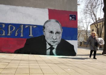 Žena prechádza okolo nástennej maľby zobrazujúcej ruského prezidenta Vladimira Putina s nápisom: Brat" v Belehrade v Srbsku v sobotu 12. marca 2022. Rusko, ktoré je historicky považované za priateľskú krajinu, je medzi Srbmi stále populárne, najmä pre podporu Moskvy v odpore Srbska voči Západom podporovanej nezávislosti odtrhnutej bývalej provincie Kosovo. (Foto: SITA/AP Photo/Darko Vojinovič)
