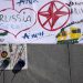 Kresby a slogany sú namaľované na veľkej plachte na chodníku pri príležitosti 23. výročia začiatku 78-dňového bombardovania Srbskom vedenej Juhoslávie zo strany NATO na Námestí republiky v Belehrade, Srbsko, štvrtok 24. marca 2022 (Foto: SITA/AP Photo/Darko Vojinovič)