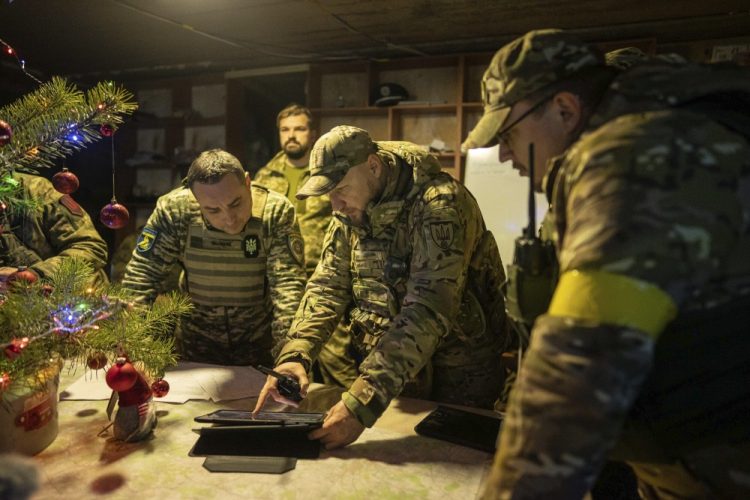 Kosjantyn Židkov "Kosťa Dziu", uprostred, ukrajinský veliteľ práporu ukazuje svoj operačný priestor Serhijovi Melnykovi "Marselovi", vľavo, generálovi ukrajinskej armády a "Djaďovi Romovi", vpravo, ukrajinskému veliteľovi brigády na frontovej línii v Charkovskej oblasti na Ukrajine v sobotu 24. decembra 2022 (Foto: SITA/AP Photo/Evgeniy Maloletka)