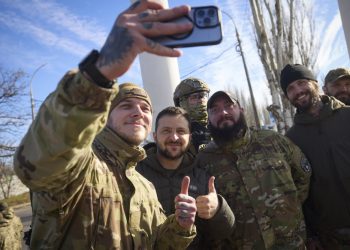 Ukrajinskí vojaci si robia selfie s prezidentom Volodymyrom Zelenským (uprostred) počas jeho návštevy Chersonu na Ukrajine v pondelok 14. novembra 202 (Foto: SITA/AP/Tlačová kancelária ukrajinského prezidenta)