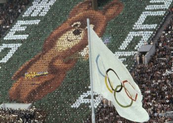 Členovia davu držia 3500 kartičiek, aby vytvorili obraz medvedieho pohára Miša, maskota moskovských olympijských hier na Leninovom štadióne v Rusku 19. júla 1980. Nad nimi horí olympijský oheň. Letné olympijské hry v Moskve v roku 1980 priniesli Sovietskemu zväzu veľa pozornosti, v dobrom aj zlom. Hry ukázali, že ZSSR dokáže byť napriek náročným vízovým procedúram pohodlný, plný dobrej nálady a pohostinný pre návštevníkov. Mnoho krajín vrátane Spojených štátov a športových veľmocí Kanady a Západného Nemecka však toto podujatie bojkotovali na protest proti invázii do Afganistanu (Foto: SITA/AP Photo/File)