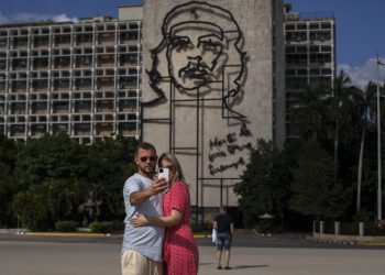 Dvojica ruských turistov si robí selfie pred obrazom ikony kubánskej revolúcie Ernesta "Che" Guevaru na Námestí revolúcie v Havane na Kube v pondelok 8. novembra 2021 (Foto: SITA/AP Photo/Ramon Espinosa)