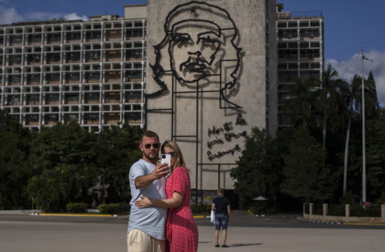 Dvojica ruských turistov si robí selfie pred obrazom ikony kubánskej revolúcie Ernesta "Che" Guevaru na Námestí revolúcie v Havane na Kube v pondelok 8. novembra 2021 (Foto: SITA/AP Photo/Ramon Espinosa)