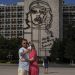 Dvojica ruských turistov si robí selfie pred obrazom ikony kubánskej revolúcie Ernesta "Che" Guevaru na Námestí revolúcie v Havane na Kube v pondelok 8. novembra 2021 (Foto: SITA/AP Photo/Ramon Espinosa)