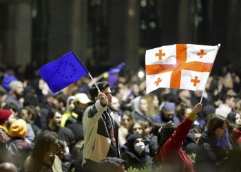 Protestujúci mávajú gruzínskou štátnou vlajkou a vlajkou EÚ počas zhromaždenia proti návrhu zákona zameraného na obmedzenie vplyvu "zahraničných agentov" neďaleko budovy gruzínskeho parlamentu v Tbilisi vo štvrtok 9. marca 2023 (Foto: SITA/AP Photo/Zurab Tsertsvadze)