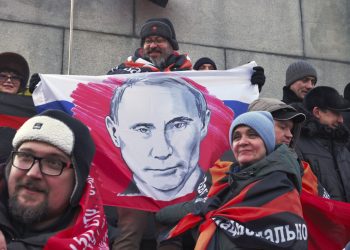 Účastníci pózujú na fotografii s plagátom s podobizňou ruského prezidenta Vladimira Putina pred koncertom "Sláva obrancom vlasti", deň pred Dňom obrancov vlasti, sviatkom na počesť ruských ozbrojených síl na štadióne Lužniki v Moskve, Rusko, v stredu 22. februára 2023 (Foto: SITA/AP Photo)