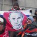 Účastníci pózujú na fotografii s plagátom s podobizňou ruského prezidenta Vladimira Putina pred koncertom "Sláva obrancom vlasti", deň pred Dňom obrancov vlasti, sviatkom na počesť ruských ozbrojených síl na štadióne Lužniki v Moskve, Rusko, v stredu 22. februára 2023 (Foto: SITA/AP Photo)