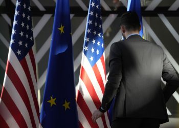 Pracovník upravuje vlajky USA a EÚ pred príchodom šéfa zahraničnej politiky Európskej únie Josepa Borrella a ministra zahraničných vecí Spojených štátov Antonyho Blinkena počas zasadnutia Rady ministrov pre energetiku EÚ - USA v budove Európskej rady v Bruseli v utorok 4. apríla 2023 (Foto: SITA/AP Photo/Virginia Mayo)