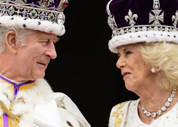 Britský kráľ Karol III. a kráľovná Camilla sa na seba pozerajú, keď stoja na balkóne Buckinghamského paláca po svojej korunovácii v Londýne v sobotu 6. mája 2023 (Foto: SITA/AP/Leon Neal)