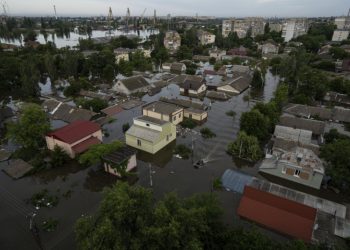 Ukrajinskí vojaci sa vezú na člne v zaplavenej štvrti v ukrajinskom Chersone vo štvrtok 8. júna 2023. Záplavy zo zrútenej priehrady v stredu na juhu Ukrajiny stále stúpali a prinútili stovky ľudí opustiť svoje domovy v rámci rozsiahlej záchrannej operácie, ktorá priniesla nový dramatický rozmer vojny s Ruskom, ktorá trvá už 16. mesiac (Foto: SITA/AP Photo/Evgeniy Maloletka)