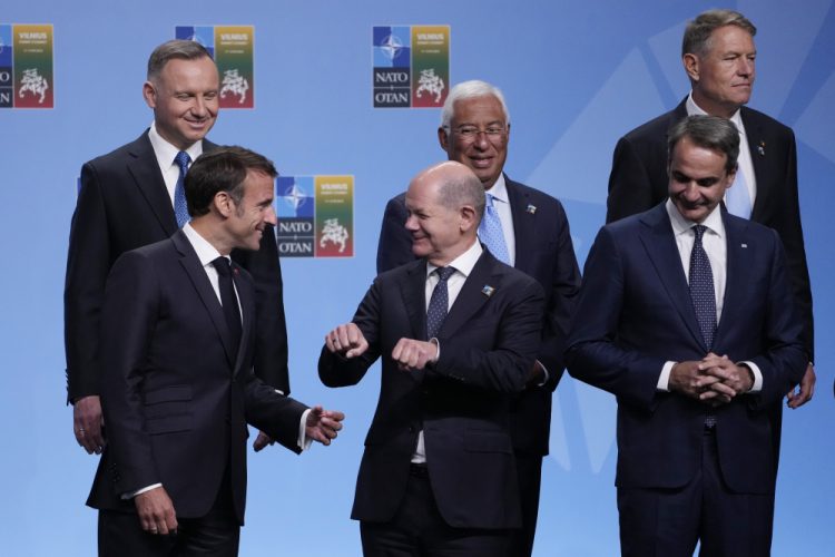 Francúzsky prezident Emmanuel Macron (v prvom rade vľavo) sa rozpráva s nemeckým kancelárom Olafom Scholzom (v prvom rade uprostred), hlavy štátov a vlád NATO sa zúčastňujú na rodinnej fotografii na samite NATO v litovskom Vilniuse v utorok 11. júla 2023. V prvom rade vpravo stojí grécky premiér Kyriakos Mitsotaki a v druhom rade zľava poľský prezident Andrzej Duda, portugalský premiér Antonio Costa a rumunský prezident Klaus Werner Iohannis (Foto: SITA/AP Photo/Susan Walsh)