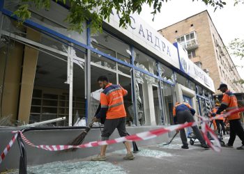 Pracovníci zametajú rozbité sklo na poškodenej budove po útoku dronom v Moskve, Rusko, pondelok 24. júla 2023 (Foto: SITA/AP Photo)