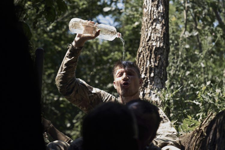 Ukrajinský vojak sa chladí vodou na frontovej línii pri Bachmute v Doneckej oblasti na Ukrajine v utorok 4. júla 2023 (Foto: SITA/AP photo/Libkos)