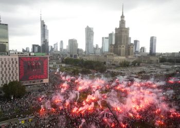 Ľudia zapaľujú svetlice v hlavnom meste Poľska, keď si krajina pripomína 79. výročie začiatku Varšavského povstania, proti nemeckým okupantom počas druhej svetovej vojny, utorok 1. augusta 2023 (Foto: SITA/AP Photo/Czarek Sokolowski)