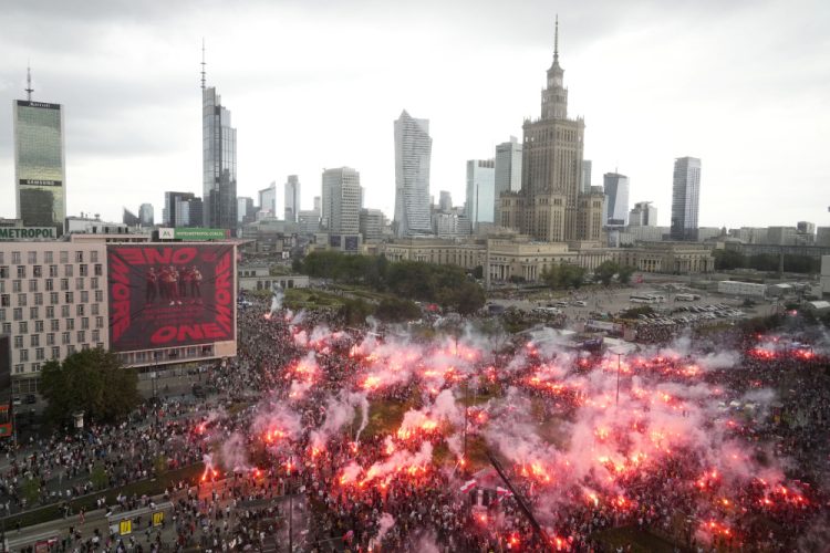Ľudia zapaľujú svetlice v hlavnom meste Poľska, keď si krajina pripomína 79. výročie začiatku Varšavského povstania, proti nemeckým okupantom počas druhej svetovej vojny, utorok 1. augusta 2023 (Foto: SITA/AP Photo/Czarek Sokolowski)