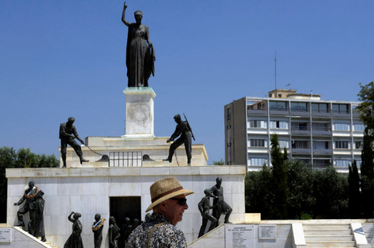 Turista stojí pred sochou vojaka (Foto: SITA/AP Photo/Petros Karadjias)