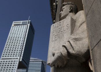 Socha s nápisom "Marx, Engels, Lenin" na fasáde Paláca kultúry a vedy vo Varšave v Poľsku v nedeľu 28. augusta 2022. Budova bola darom od Josifa Stalina. Je súčasťou života mesta a získala štatút ochrany ako miesto historického významu (Foto: SITA/AP Photo/Michal Dyjuk)