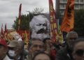 Tisíce ľudí mávajú vlajkami a transparentmi vrátane obrovského plagátu nemeckého filozofa Karla Marxa počas prvomájového protestu v tureckej Ankare v nedeľu 1. mája 2022. Turecká poriadková polícia rýchlo zasiahla v Istanbule a obkľúčila protestujúcich neďaleko zamrežovaného námestia Taksim, kde v roku 1977 počas prvomájového podujatia zahynulo 34 ľudí, keď sa do davu strieľalo z neďalekej budovy (Foto: SITA/AP Photo/Burhan Ozbilici)