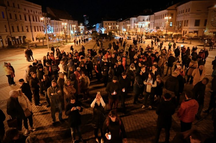 Účastníci spomienkovej prechádzky Banskou Bystricou počas zapaľovania sviečok pri Mariánskom stĺpe na Námestí SNP pri príležitosti 34. výročia Dňa boja za slobodu a demokraciu. Banská Bystrica, 17. november 2023 (Foto: SITA/Jakub Julény)