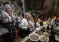 Rodina Zelenčukových sa modlí pred štedrovečernou večerou v ukrajinskej dedine Kryvorivňa v nedeľu 24. decembra 2023 (Foto: SITA/AP Photo/Evgeniy Maloletka)